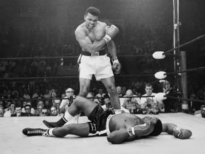 ﻿FILE - In this May 25, 1965, file photo, heavyweight champion Muhammad Ali, then known as Cassius Clay, stands over challenger Sonny Liston, shouting and gesturing shortly after dropping Liston with a short hard right to the jaw, in Lewiston, Maine. Ali, the magnificent heavyweight champion whose fast fists and irrepressible personality transcended sports and captivated the world, has died according to a statement released by his family Friday, June 3, 2016. He was 74. (AP Photo/John Rooney, File) / Foto: John Rooney