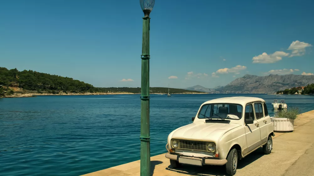 An old car parked near a street lamp and the sea on the island of Brac in Croatia / Foto: Tatiana Zayats