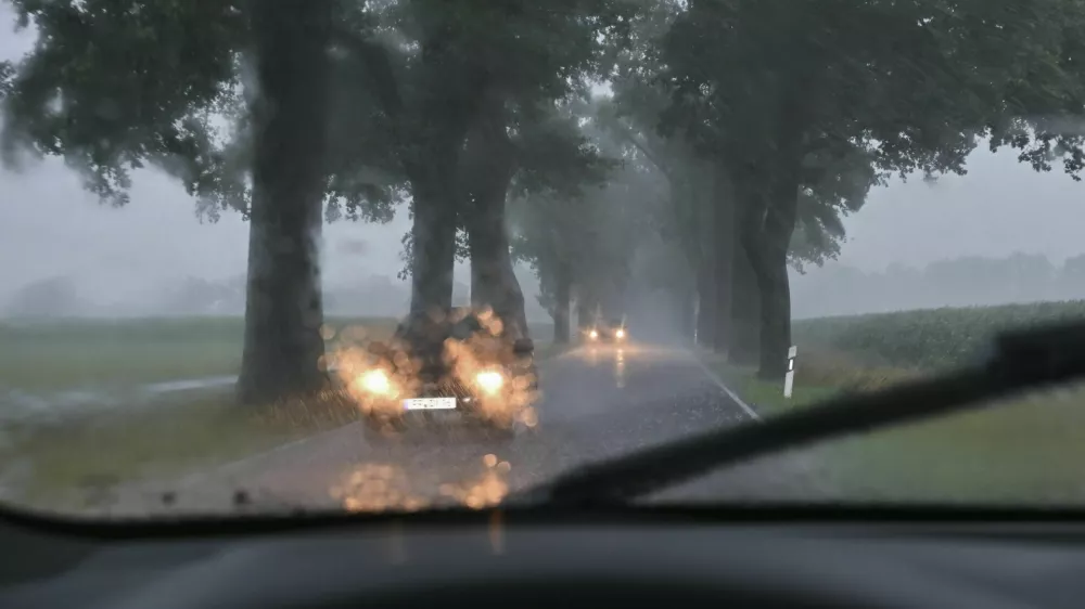 dpatop - 12 July 2024, Brandenburg, Sieversdorf: Heavy rainfall obstructs traffic on an avenue in the Oder-Spree district in eastern Brandenburg. The weekend in Brandenburg gets off to an uncomfortable start with thunderstorms and heavy rain. The German Weather Service (DWD) warns of local rainfall of up to 80 liters per square meter within a few hours. Photo by: Patrick Pleul/picture-alliance/dpa/AP Images