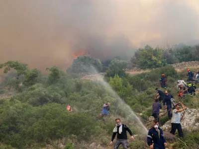 Firefighters and volunteers try to tackle a wildfire burning near the village of Agios Georgios Sikousis, on Chios island, Greece, June 23, 2025. REUTERS/Konstantinos Anagnostou
