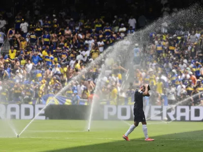 Auckland City's Gerard Garriga cools off under the sprinklers during a water break in the Club World Cup Group C soccer match between Auckland City and Boca Juniors in Nashville, Tenn., Tuesday, June 24, 2025. (AP Photo/George Walker IV)