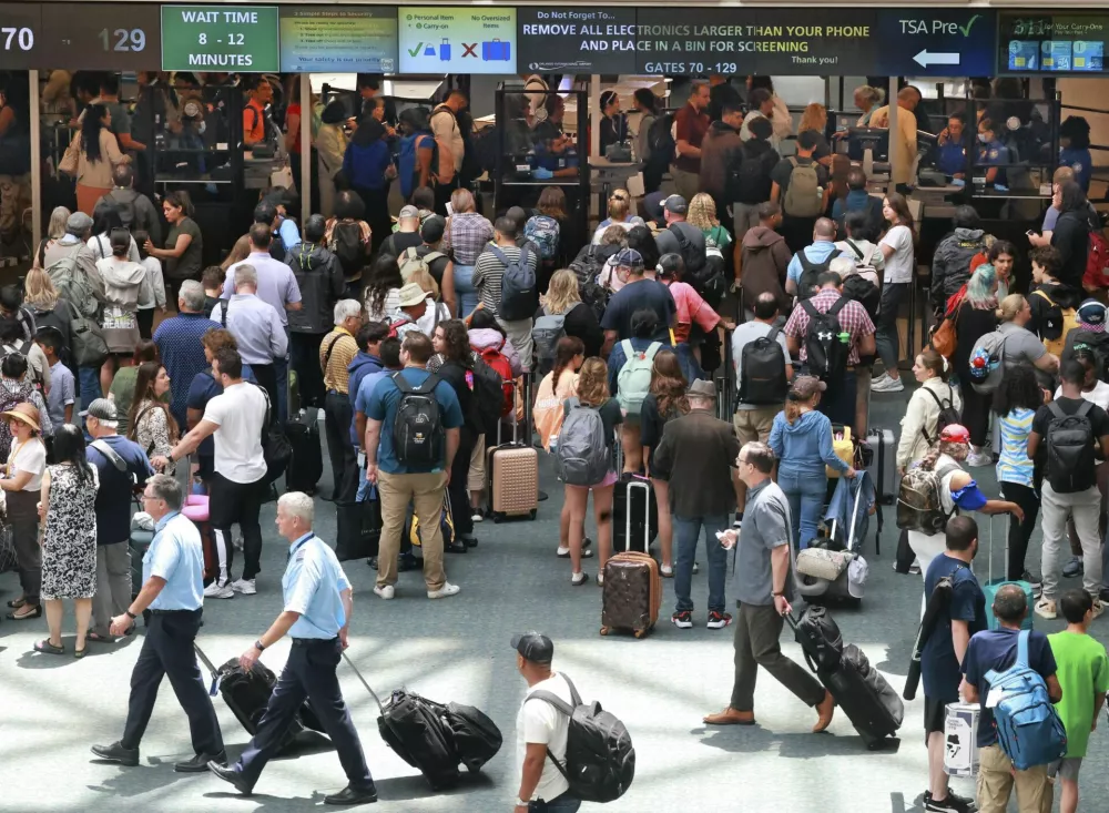FILE - Travelers wait in line for security in the east hall atrium at Orlando International Airport, Thursday, May 25, 2023 in Orlando, Fla. (Joe Burbank /Orlando Sentinel via AP, File)