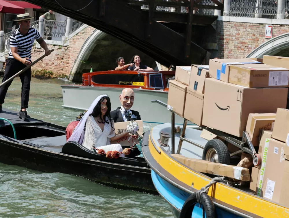 Gondolier rows a gondola with mannequins depicing Amazon Founder Jeff Bezos and his fiancee Lauren Sanchez in wedding attire, as part of a parody stunt by art collective Konn Artiss, ahead of the anticipated wedding of Bezos and Sanchez in Venice, Italy, June 24, 2025. Click News/Handout via REUTERS  THIS IMAGE HAS BEEN SUPPLIED BY A THIRD PARTY. NO RESALES. NO ARCHIVES. MANDATORY CREDIT.