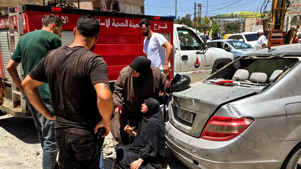 27 June 2025, Lebanon, Nabatieh: A woman is helped at the site where an apartment was destroyed in the Lebanese city of Nabatieh following a series of Israeli air strikes targeting underground assets of pro-Iranian Hezbollah in the outskirts of the city. Photo: Stringer/dpa