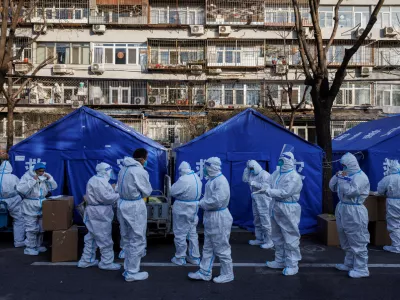 Pandemic prevention workers gather before their shift to look after buildings where residents do home quarantine, as coronavirus disease (COVID-19) outbreaks continue in Beijing, December 8, 2022. REUTERS/Thomas Peter   TPX IMAGES OF THE DAY