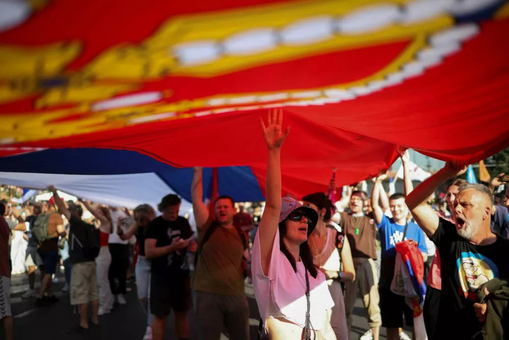 Demonstrators hold a large Serbian flag as they attend an anti-government protest demanding snap elections, at the Slavija square, in Belgrade, Serbia, June 28, 2025. REUTERS/Marko Djurica
