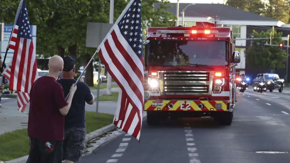 A procession from Kootenai Health headed to Spokane after a few firefighters were killed Sunday, June 29, 2025, when they were ambushed by sniper fire while responding to a blaze in a northern Idaho mountain community, in Coeur d'Alene, Idaho. (Bill Buley/Coeur D'Alene Press via AP)