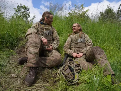 20-year-old conscript Katrine, right, speaks with another female conscript during final exercises at a training area close to Royal Danish Army's barracks in Hovelte, 25 kilometres north of Copenhagen, Denmark, Wednesday, June 11, 2025. (AP Photo/James Brooks)