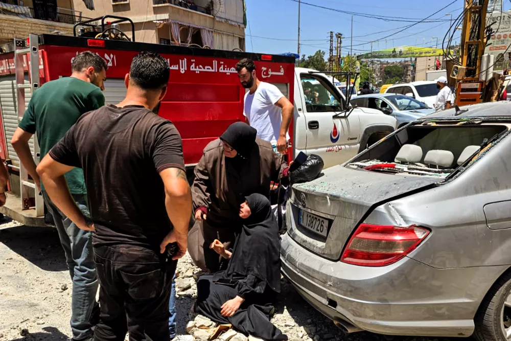 27 June 2025, Lebanon, Nabatieh: A woman is helped at the site where an apartment was destroyed in the Lebanese city of Nabatieh following a series of Israeli air strikes targeting underground assets of pro-Iranian Hezbollah in the outskirts of the city. Photo: Stringer/dpa