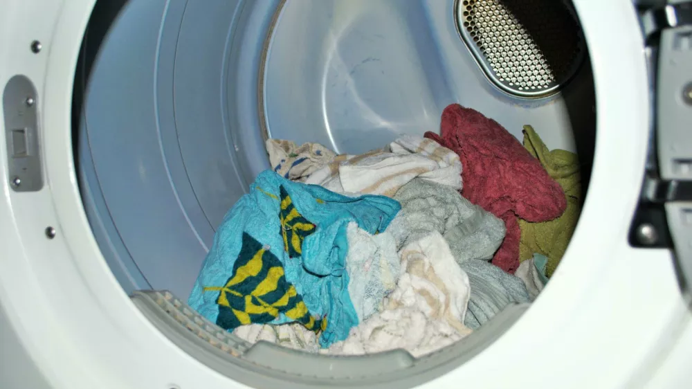 2DENKTA Load of wet towels going into the dryer on laundry day