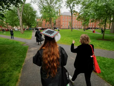 FILE PHOTO: People walk to attend the 374th Commencement exercises at Harvard University in Cambridge, Massachusetts, U.S., May 29, 2025. REUTERS/Brian Snyder/File Photo