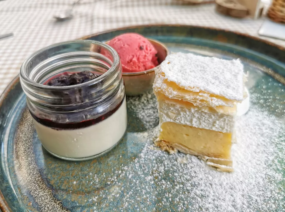 Panakoto, manjša kremšnita in jagodov sladoled na čokoladnem drobljencu. / Foto: Miha First