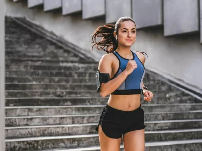 Young caucasian woman runner jogging on the stairs in sporty outfit outdoors / Foto: Inside Creative House