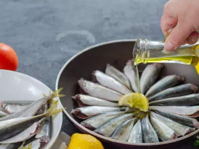 Woman is pouring olive oil into the pan. / Foto: Nkeskin