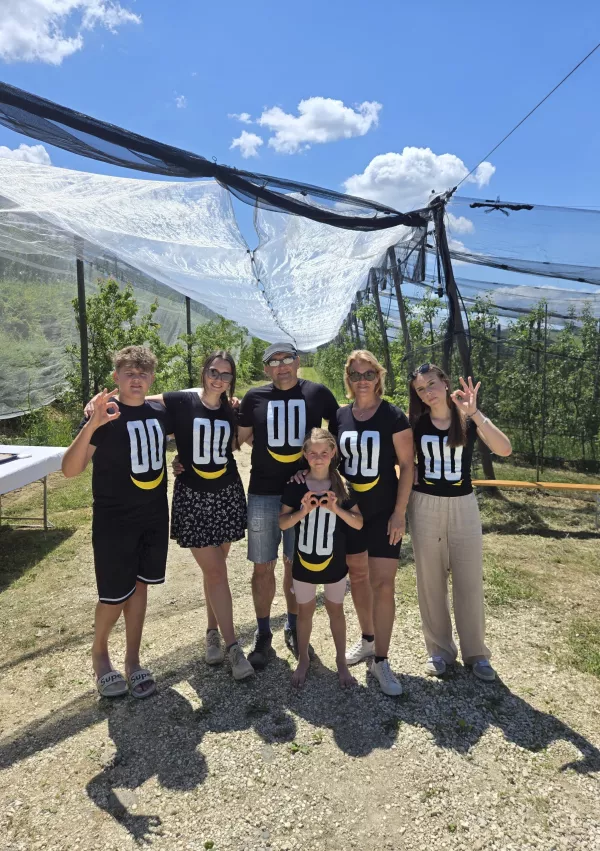 Družina Trstenjak v nasadu jablan. / Foto: Osebni Arhiv