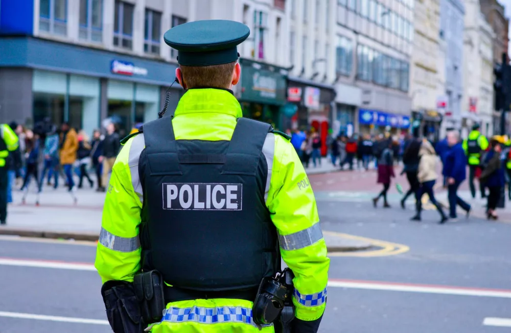 Belfast, Northern Ireland, UK, March 17, 2018. Back view of a policeman in a busy street at Belfast city centre during St Patrick's Day celebration, Northern Ireland. / Foto: Min Jing