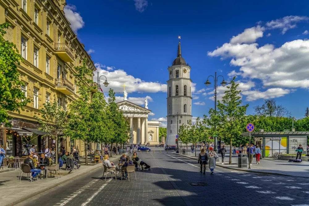 Vilnius, Lithuania - May 30, 2021: View to main Vilnius city street - Gedimino avenue, Vilnius Cathedral and bell tower with people walking and riding bike in sunny day. / Foto: Vejaa