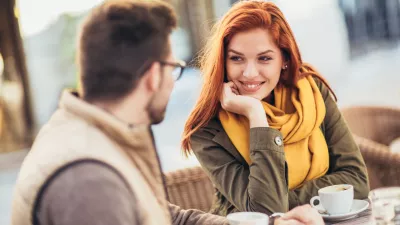 Attractive young couple in love sitting at the cafe table outdoors, drinking coffee / Foto: Jovanmandic