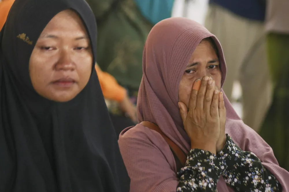 A passenger's relative weeps after a ferry carrying dozens of passengers sank near the resort island of Bali, at Ketapang Port in Bayuwangi, East Java, Indonesia, Thursday, Juli 3, 2025. (AP Photo/Andur)
