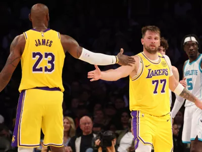 Feb 19, 2025; Los Angeles, California, USA; Los Angeles Lakers forward LeBron James (23) and guard Luka Doncic (77) celebrate after a play during the third quarter against the Charlotte Hornets at Crypto.com Arena. Mandatory Credit: Jason Parkhurst-Imagn Images