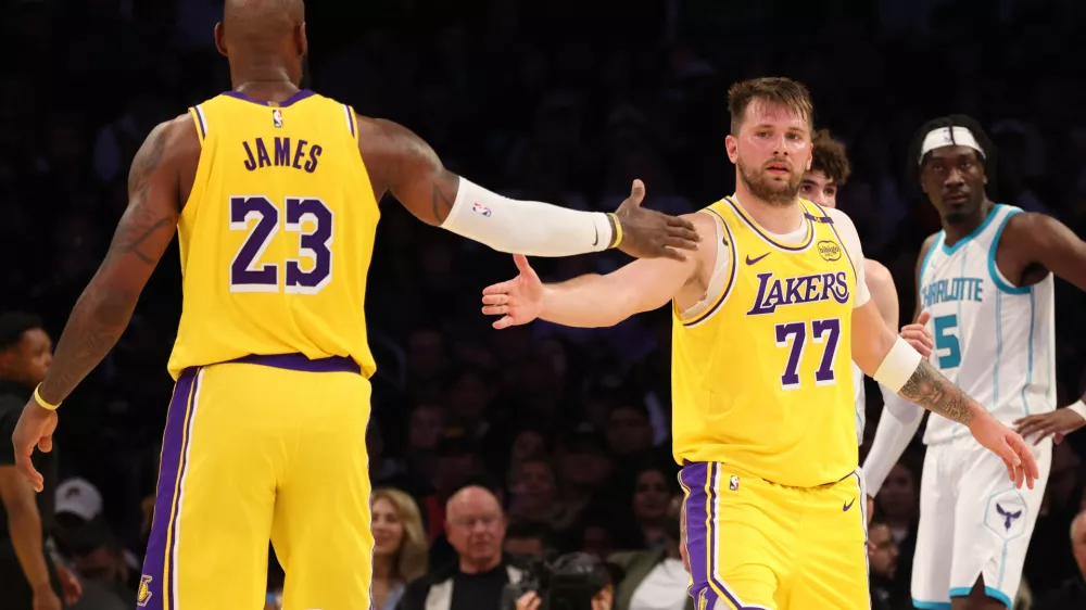 Feb 19, 2025; Los Angeles, California, USA; Los Angeles Lakers forward LeBron James (23) and guard Luka Doncic (77) celebrate after a play during the third quarter against the Charlotte Hornets at Crypto.com Arena. Mandatory Credit: Jason Parkhurst-Imagn Images