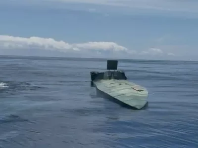 SANTA MARTA, COLOMBIA - JULY 2: (-----EDITORIAL USE ONLY MANDATORY CREDIT - 'COLOMBIAN NAVY PRESS OFFICE / HANDOUT' - NO MARKETING NO ADVERTISING CAMPAIGNS - DISTRIBUTED AS A SERVICE TO CLIENTS-----) A low-profile unmanned semi-submersible vessel sits between two Colombian Navy boats off the coast of Tayrona Park near Santa Marta, Colombia, on July 2, 2025. The Orion Multinational Strategy, led by the Colombian Navy, warns of a growing threat: the use of autonomous technologies by drug trafficking networks. In early 2025, Colombia seized its first autonomous semi-submersible in the Caribbean, a case that reflects a shift toward more sophisticated, radar-evading systems. Colombian Navy Press Office / Handout / AnadoluNo Use USA No use UK No use Canada No use France No use Japan No use Italy No use Australia No use Spain No use Belgium No use Korea No use South Africa No use Hong Kong No use New Zealand No use Turkey