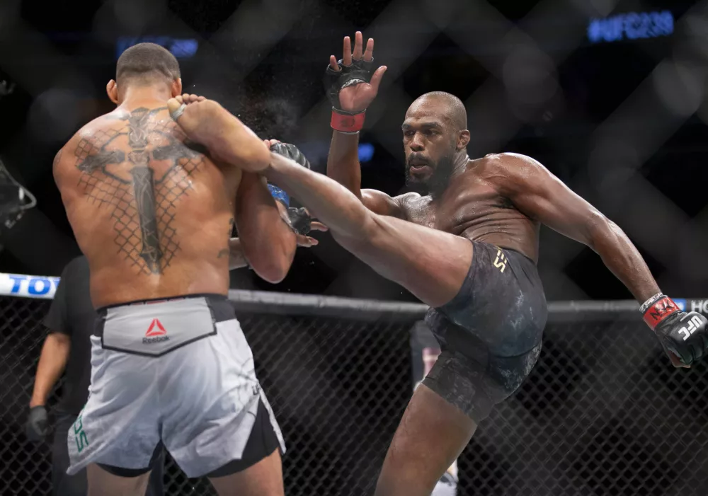 ﻿File - In this July 6, 2019, file photo, Jon Jones, right, lands a kick on Thiago Santos during their light heavyweight mixed martial arts title bout at UFC 239 in Las Vegas. UFC light heavyweight champion Jon Jones is denying allegations that he assaulted a waitress in a New Mexico strip club. Denise White, a representative for Jones, said in a statement Monday, July 22, 2019, that he is confident he will be cleared of the "baseless claim." (AP Photo/Eric Jamison, File)