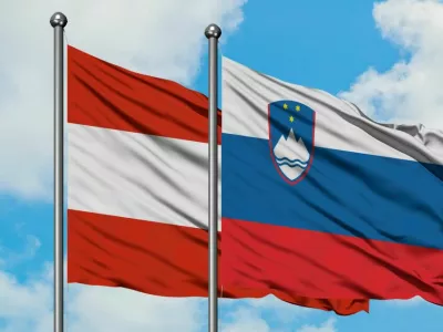 ﻿Austria and Slovenia flag waving in the wind against white cloudy blue sky together. Diplomacy concept, international relations.