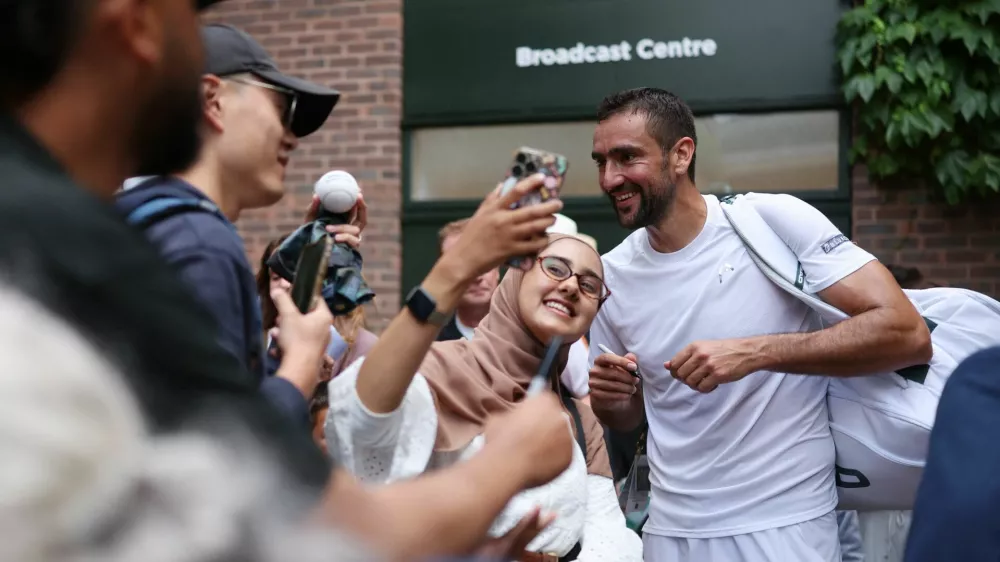 Tennis - Wimbledon - All England Lawn Tennis and Croquet Club, London, Britain - July 5, 2025 Croatia's Marin Cilic with fans as he leaves the court after winning his third round match against Spain's Jaume Munar REUTERS/Isabel Infantes