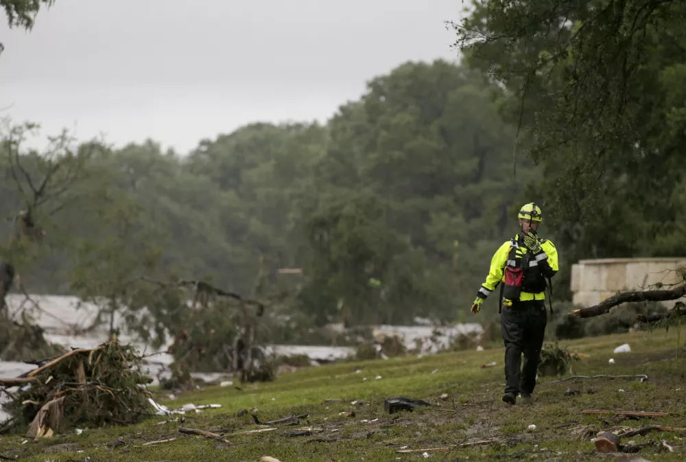04 July 2025, US, Kerrville: A Kerrville firefighter scans the banks of the Guadalupe River in Ingram, TX as rescue efforts to find individuals swept away in early morning flooding on July 4, 2025. Photo: San Antonio Express-News/Express-News via ZUMA Press Wire/dpa