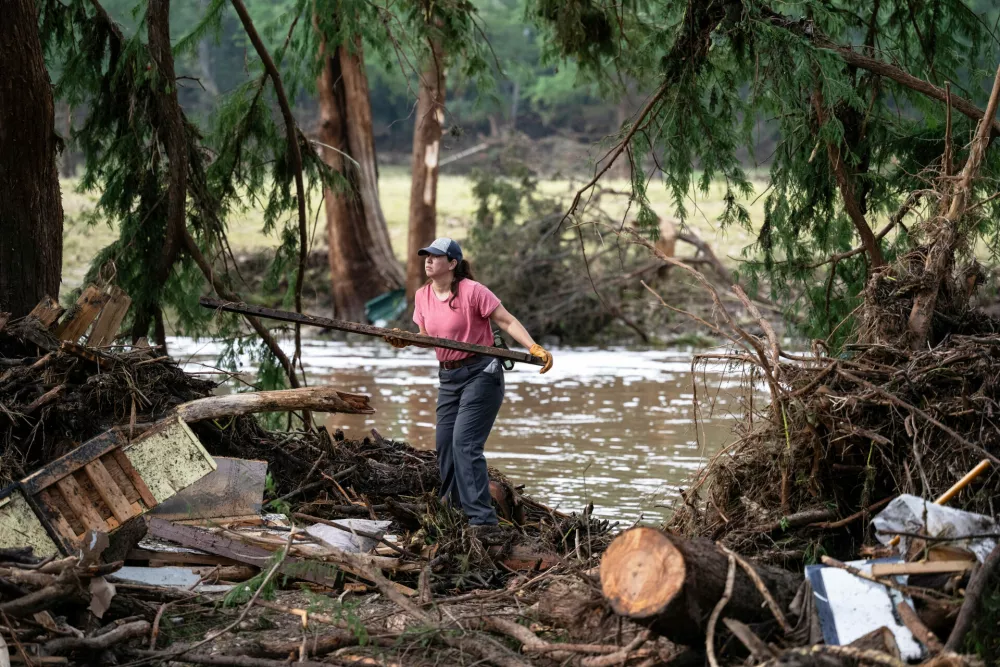 A volunteer aids in search and rescue operations near the Guadalupe River after a flash flood swept through the area, Monday, July 7, 2025, in Ingram, Texas. (AP Photo/Eli Hartman)