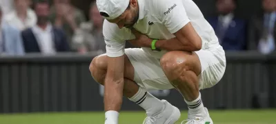 Bulgaria's Grigor Dimitrov clutches his chest with an injury which forced him to retire injured from a fourth round men's singles match against Italy's Jannik Sinner at the Wimbledon Tennis Championships in London, Monday, July 7, 2025. (AP Photo/Kin Cheung)