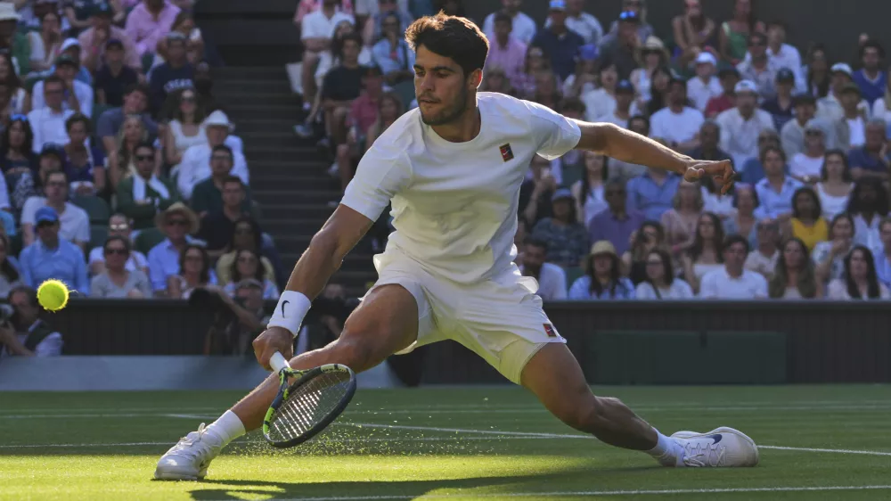Spain's Carlos Alcaraz returns to Britain's Cameron Norrie during a quarterfinal men's singles match at the Wimbledon Tennis Championships in London, Tuesday, July 8, 2025. (AP Photo/Kirsty Wigglesworth)