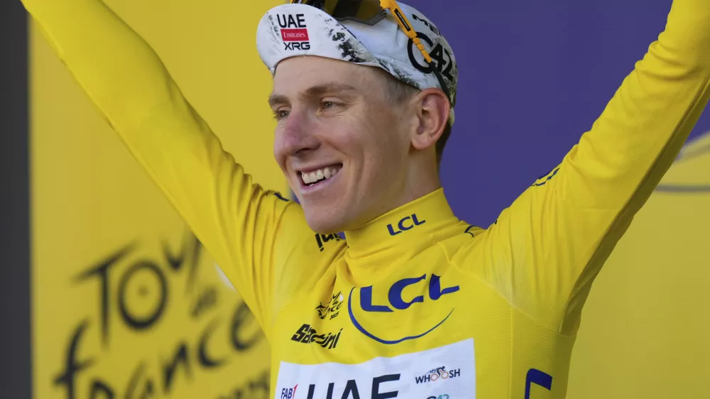 Slovenia's Tadej Pogacar wearing the overall leader's yellow jersey celebrates on the podium after the fifth stage of the Tour de France cycling race, an indivdual time-trial over 33 kilometers (20.5 miles) with start and finish in Caen, France, Wednesday, July 9, 2025. (AP Photo/Mosa'ab Elshamy)