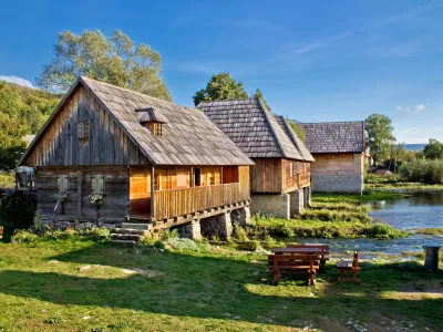 Stara zgodovinska vas z lesenimi kočami ob izviru reke Gacke. F istock