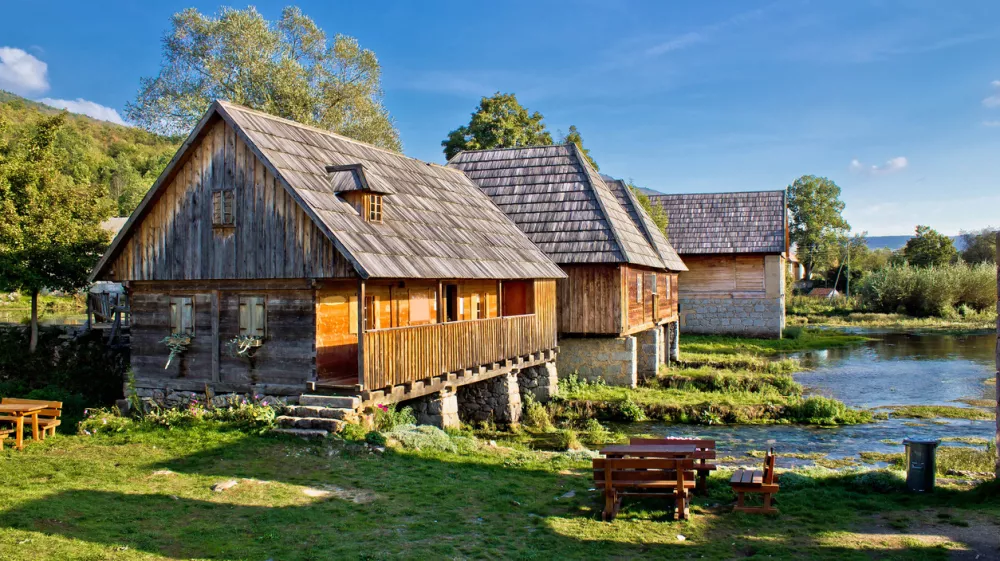 Stara zgodovinska vas z lesenimi kočami ob izviru reke Gacke. F istock