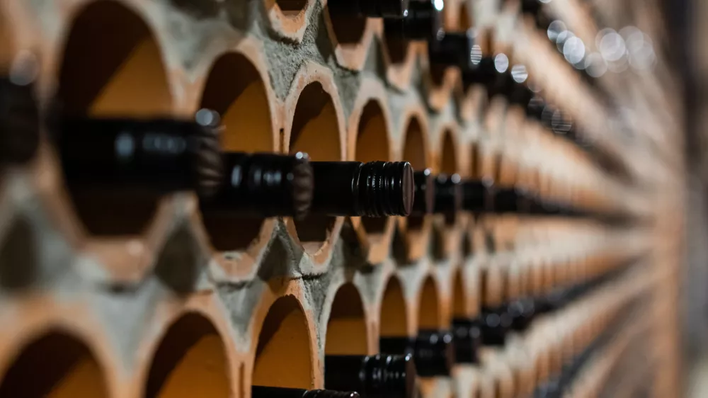 Archive of red wine with black corks in the wine cellar in special brick openings. Bela Krajina, Slovenia