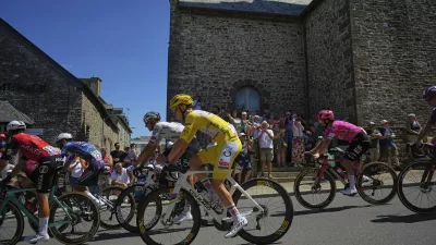 Ireland's Ben Healy, right in pink jersey, follows Slovenia's Tadej Pogacar, wearing the overall leader's yellow jersey, during the eighth stage of the Tour de France cycling race over 171.4 kilometers (106.5 miles) with start in Saint-Meen-le-Grand and finish in Laval Espace Mayenne, France, Saturday, July 12, 2025. (AP Photo/Thibault Camus)