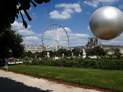 The Vasque (cauldron) of Paris 2024 floats attached to a hot air balloon, with a 100% electric and non-Olympic flame in Paris, France, July 12, 2025. REUTERS/Tom Nicholson