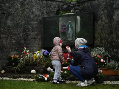 ﻿Denise Gormley and her daughter Rosa, 7, pay their respects and blow bubbles at the Tuam graveyard, where the bodies of 796 babies were uncovered at the site of a former Catholic home for unmarried mothers and their children, on the day a government-ordered inquiry into former Church-run homes for unmarried mothers is formally published, in Tuam, Ireland, January 12, 2021. REUTERS/Clodagh Kilcoyne