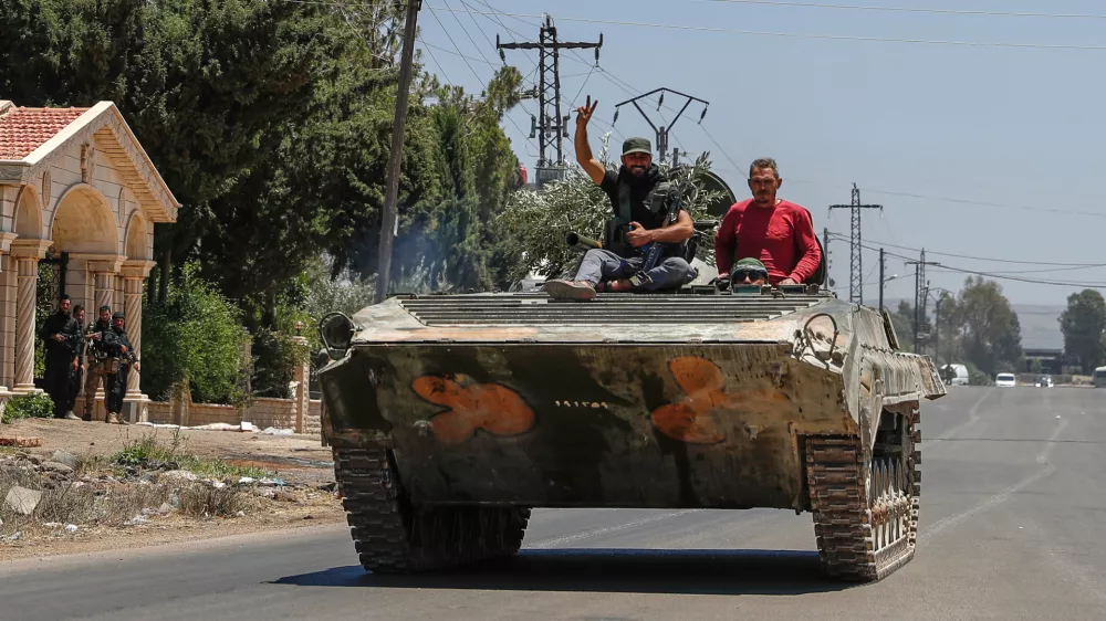 Syrian government forces sit on their armored personnel carrier, as they withdraw from Sweida city, southern Syria, Tuesday, July 15, 2025.(AP Photo/Ghaith Alsayed)