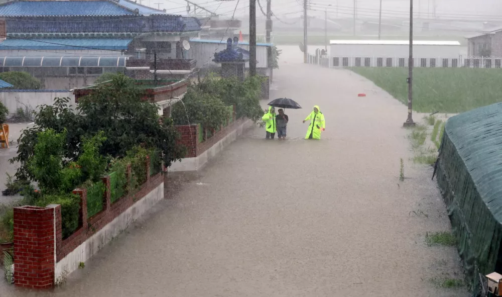 Policemen evacuate a resident from a flooded area following torrential rains in Changnyeong, South Korea, July 17, 2025.  Yonhap via REUTERS  THIS IMAGE HAS BEEN SUPPLIED BY A THIRD PARTY. NO RESALES. NO ARCHIVES. SOUTH KOREA OUT. NO COMMERCIAL OR EDITORIAL SALES IN SOUTH KOREA.