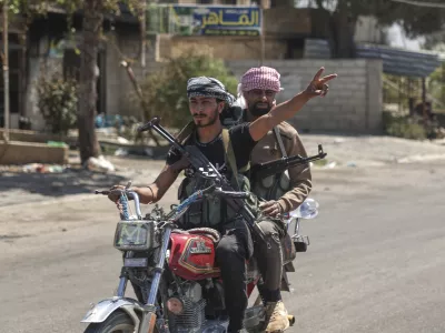A Bedouin fighter flashes victory sign as he rides a motorcycle at Mazraa village on the outskirts of Sweida city, where clashes erupted between theBedouin clans and Druze militias, southern Syria, Friday, July 18, 2025. (AP Photo/Ghaith Alsayed)