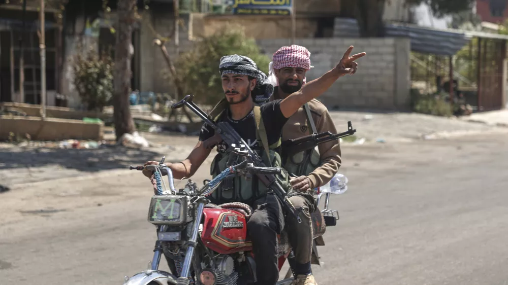A Bedouin fighter flashes victory sign as he rides a motorcycle at Mazraa village on the outskirts of Sweida city, where clashes erupted between theBedouin clans and Druze militias, southern Syria, Friday, July 18, 2025. (AP Photo/Ghaith Alsayed)