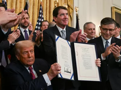 U.S. President Donald Trump holds the signed "Genius Act", which will develop regulatory framework for stablecoin cryptocurrencies and expand oversight of the industry, at the White House in Washington, D.C., U.S., July 18, 2025. REUTERS/Annabelle Gordon