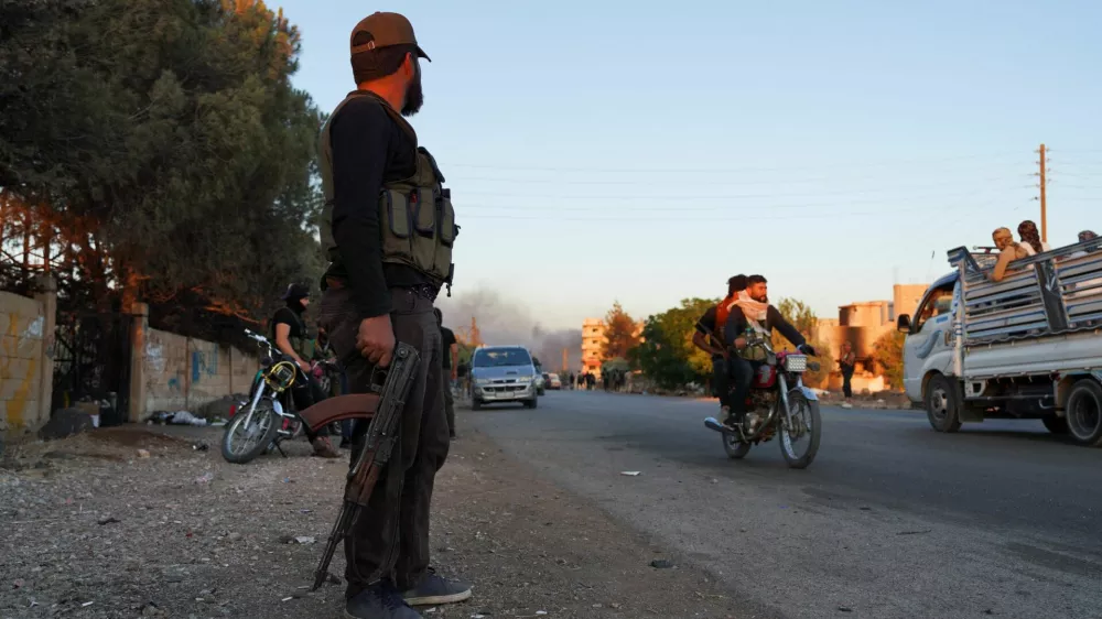 A Bedouin fighter holds a weapon as he stands along a street, as Sweida province has been engulfed by nearly a week of violence triggered by clashes between Bedouin fighters and factions from the Druze, at Sweida governorate, Syria, July 18, 2025. REUTERS/Karam al-Masri