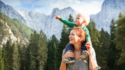 Srečna mamica z otročičkom med lepimi gorami.
