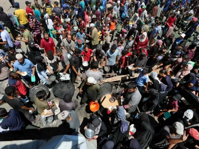 Palestinians gather to receive food from a charity kitchen, amid a hunger crisis, in Nuseirat, central Gaza Strip, July 20, 2025. REUTERS/Ramadan Abed