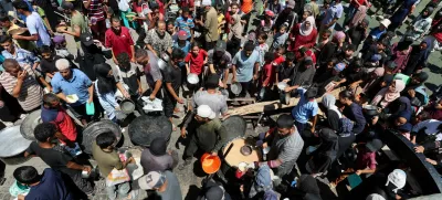 Palestinians gather to receive food from a charity kitchen, amid a hunger crisis, in Nuseirat, central Gaza Strip, July 20, 2025. REUTERS/Ramadan Abed