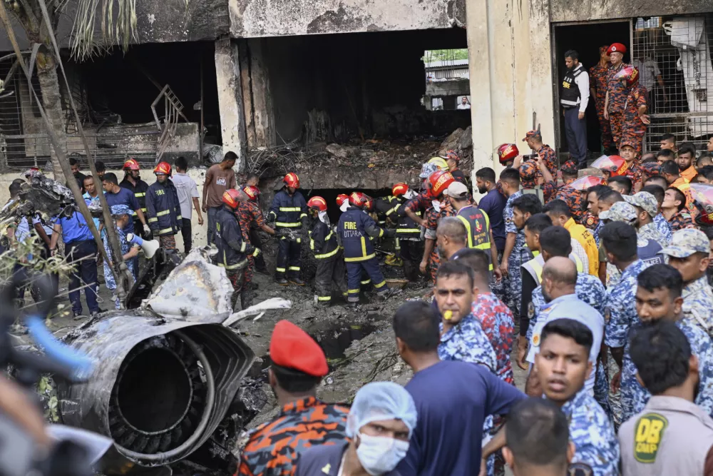 Firemen look for the survivors after a Bangladesh Air Force training aircraft that crashed onto a school campus shortly after takeoff in Dhaka, Bangladesh, Monday, July 21, 2025. (AP Photo/Mahmud Hossain Opu)